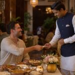 Foreign tourist handing cash to a hotel restaurant staff member after dinner in India, illustrating tipping etiquette and paying for hospitality services during travel.